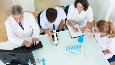 Four medical personnel working at a table together