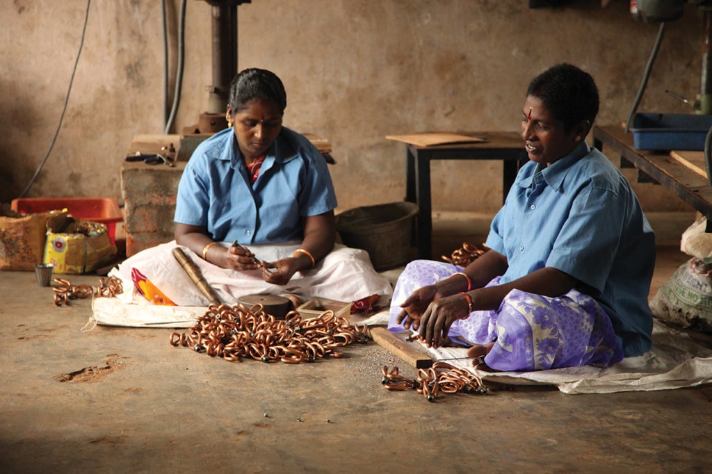 Women at an extraction plant in Hyderabad, India, work with copper chains to create Servals’ clean-energy products.