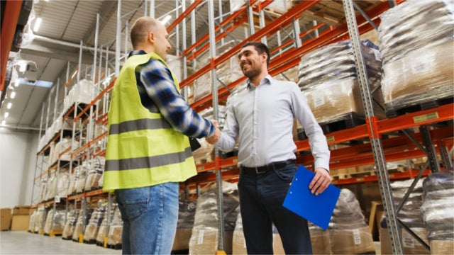 Warehouse employee and manager shaking hands