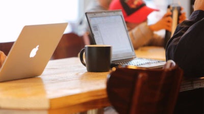 Workers sitting at laptops in a cafe