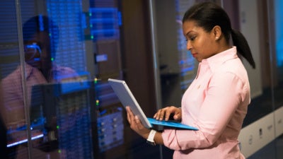 Woman Wearing Pink Dress Shirt Holding Gray Laptop Computer
