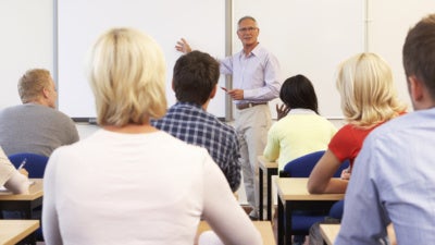 Teacher lecturing to a college classroom full of students