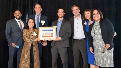 Representatives from LendingClub, Opportunity Fund, CAMEO, CDC Small Business, and Small Business Majority on stage to collect a Community Heroes award from California Reinvestment Coalition. Left to right: Gabrielle Villareal of Opportunity Fund, Heidi Pickman of CAMEO, Kurt Chilcott of CDC Small Business, Louis Caditz-Peck of LendingClub, Brian Pifer of Small Business Majority, Gwendy Brown of Opportunity Fund, Paulina Gonzalez of California Reinvestment Coalition.
