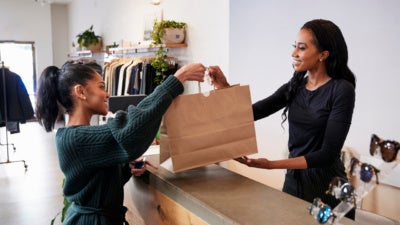 Woman serving customer at the counter in a clothing store