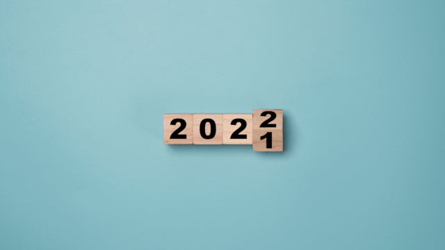 Photo of wooden blocks spelling out the year. The final block is in the process of flipping from 2021 to 2022.