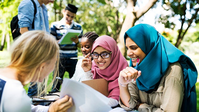 Diverse children studying outdoors