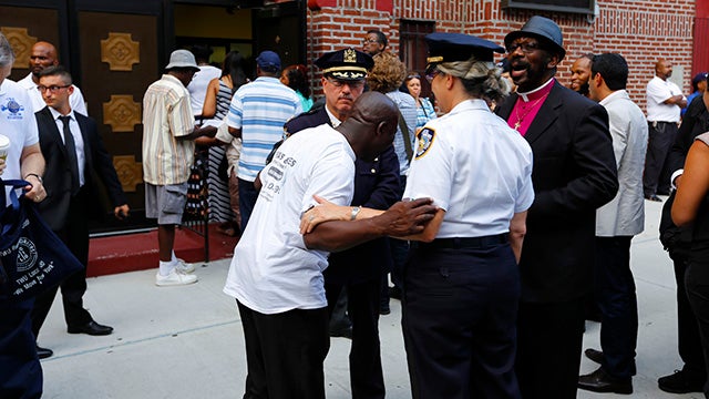 Crowd of mourners and police at Eric Garner's funeral in NYC