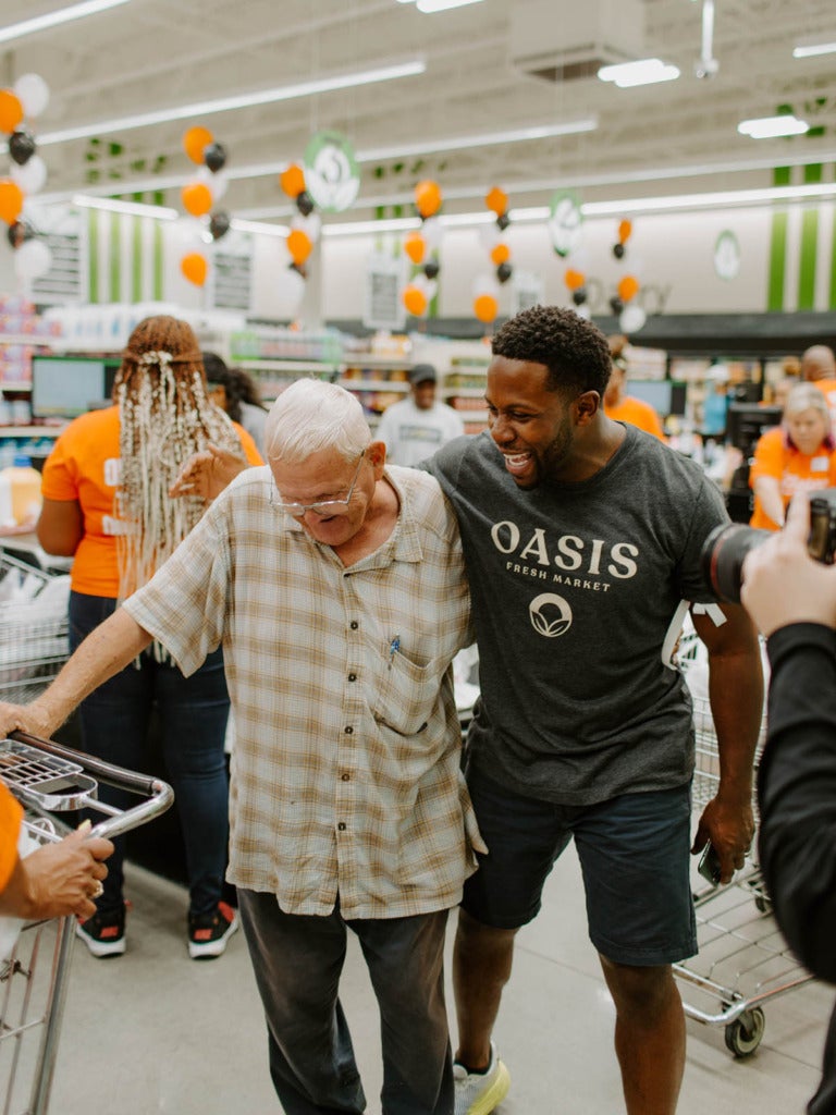 Man with elderly customer in grocery store