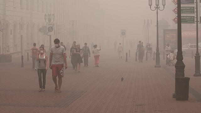 People in city street filled with smog