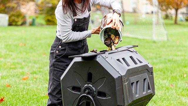 Woman dumping food scraps into composter