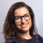 Iskrena Blinznakova's headshot. A person with medium-length hair wearing glasses smiles at the camera.