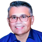 Jose Castejon's headshot. Image depicts a person with short hair wearing glasses and a collared shirt smiling at the camera.