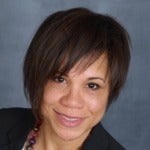 Judy March's headshot. Image depicts a person with short hair and bangs wearing a jacket smiling at the camera.