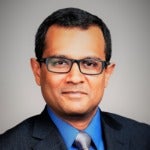 Vishnu G Venkatesh's headshot. Image depicts a person with short hair wearing glasses, a jacket, and a tie looking at the camera.