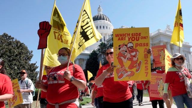 Fast-food workers and their supporters march past the Capitol in Sacramento on August 16