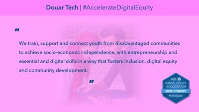 This graphic reads, "We train, support and connect youth from disadvantaged communities to achieve socio-economic independence, with entrepreneurship and essential and digital skills in a way that fosters inclusion, digital equity and community development." “Douar Tech” and “#AccelerateDigitalEquity" comprise the headline. In the background, a photograph depicts a two people, one wearing a head covering, looking at a computer tablet together. The bottom corner includes a badge icons that reads, "Digital Equity Accelerator 2022 Cohort Participant."