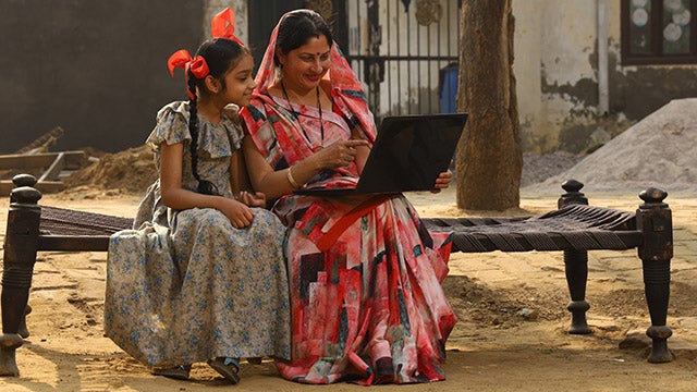 Mother and child on laptop in rural India