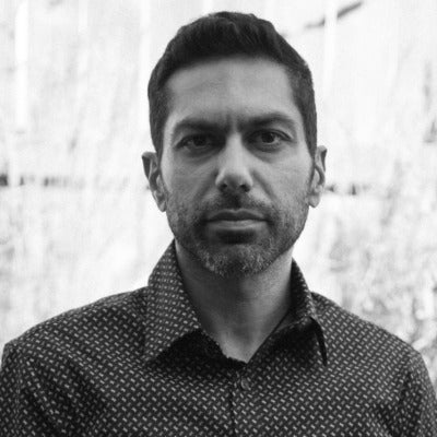 Headshot of man, unsimiling, in black and white with a goatee