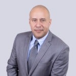 Professional photo of bald man with gray jacket and tie