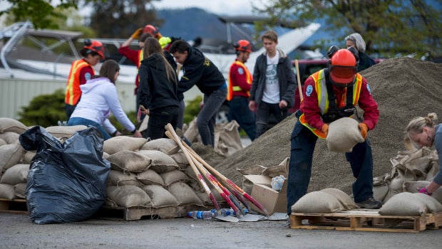 Natural disaster response workers moving sand bags