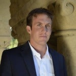 headshot of author Nick Romeo wearing a white shirt and dark jacket