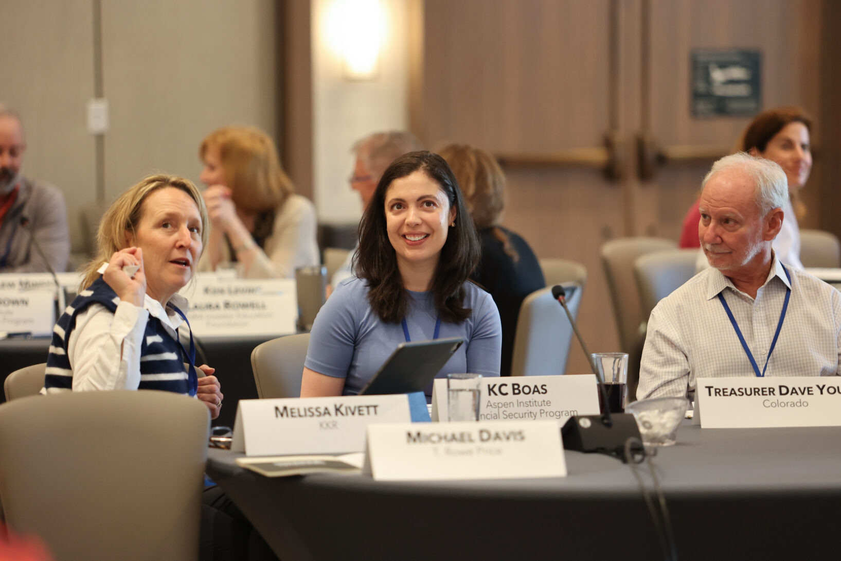 three people sit at a table in discussion