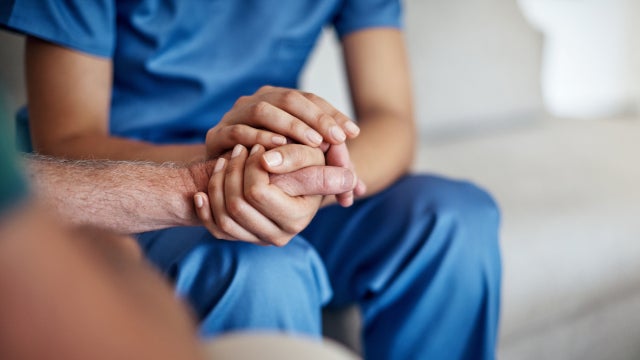 Closeup photo of a domestic worker holding someone's hand