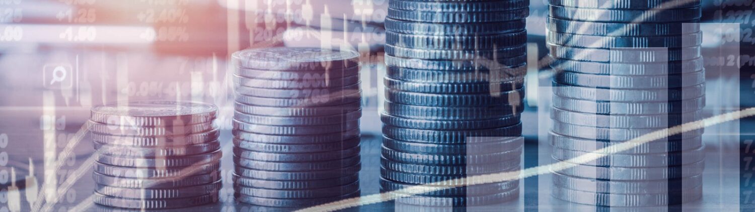Various charts trending upward, superimposed on a photo of four stacks of coins ascending in height.