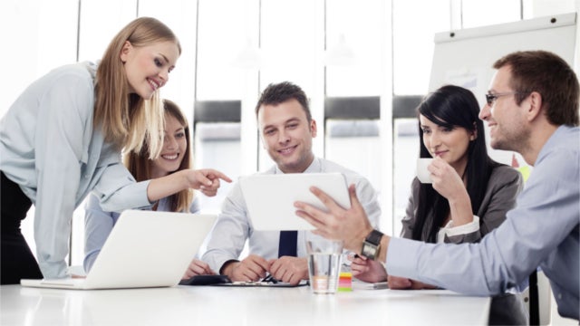 Office workers gathered around a tablet