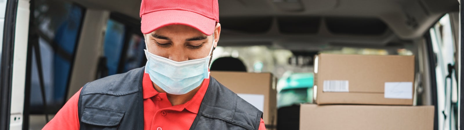 Photo of a delivery worker wearing a face mask and gloves