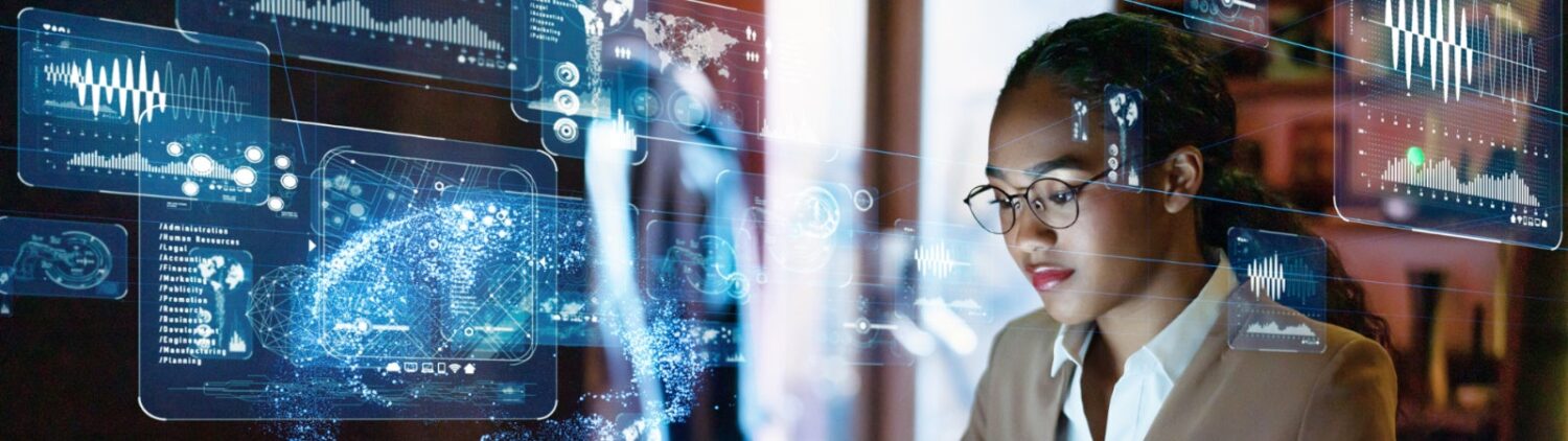 Photo of a woman working at a laptop with technology symbols floating around her