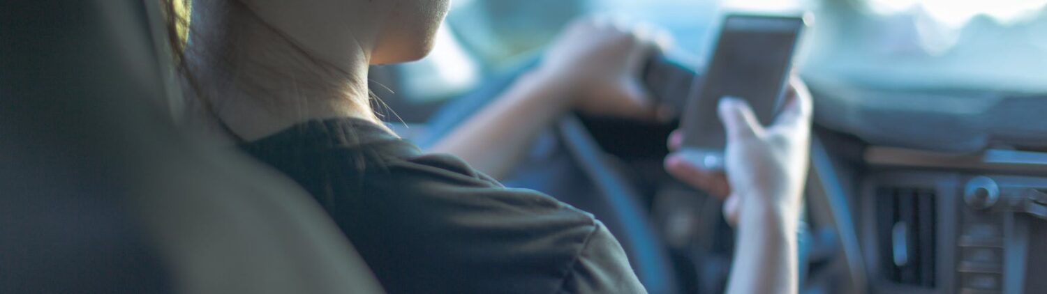 Woman using smartphone while driving
