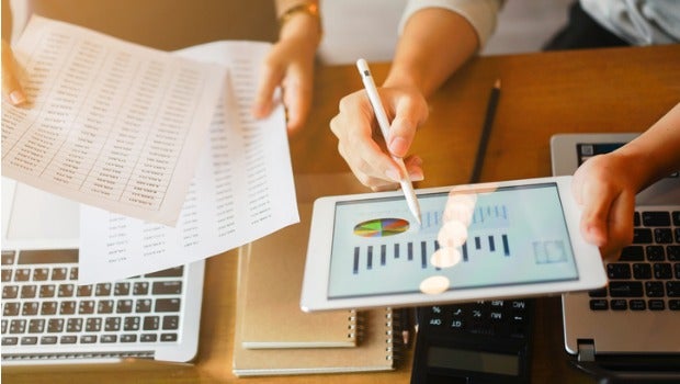 People looking over business plans on a tablet