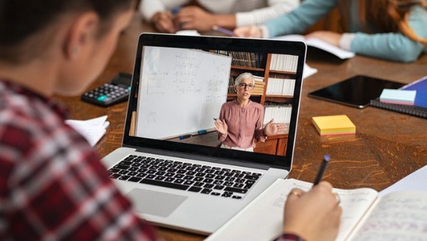A student taking notes on an online lecture.