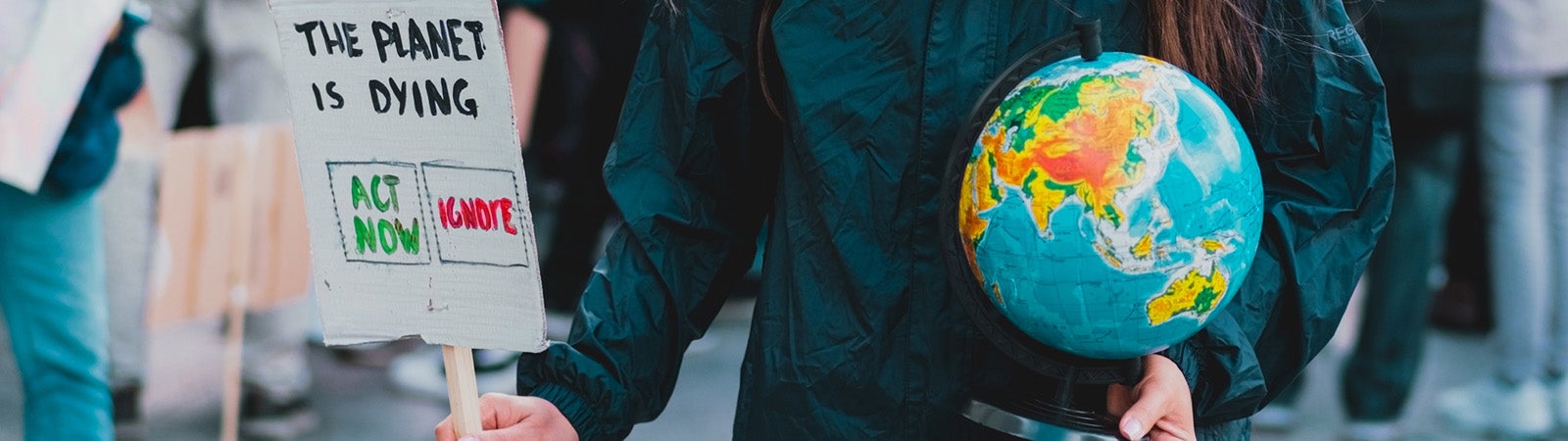 Woman holding globe and sign at climate protest