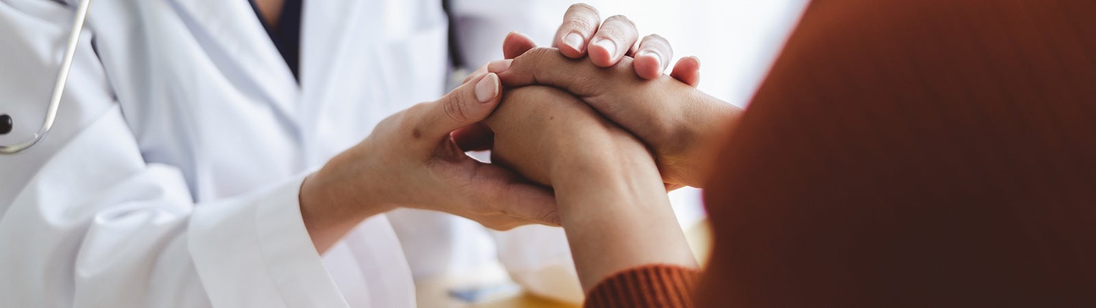 Doctor holding hands with patient