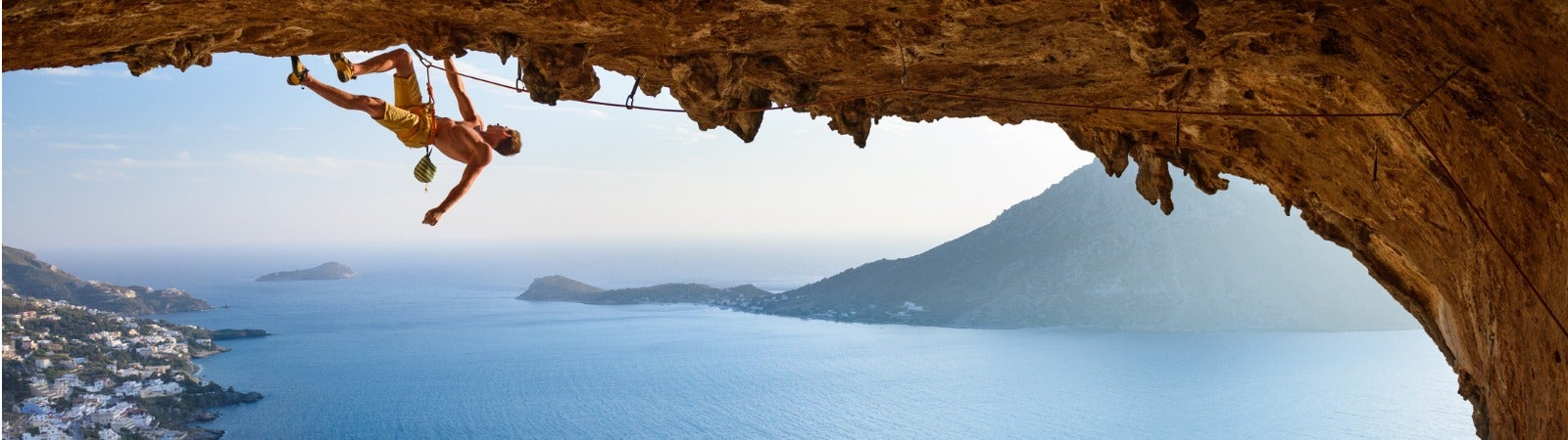 A man rock climbing in a cave.