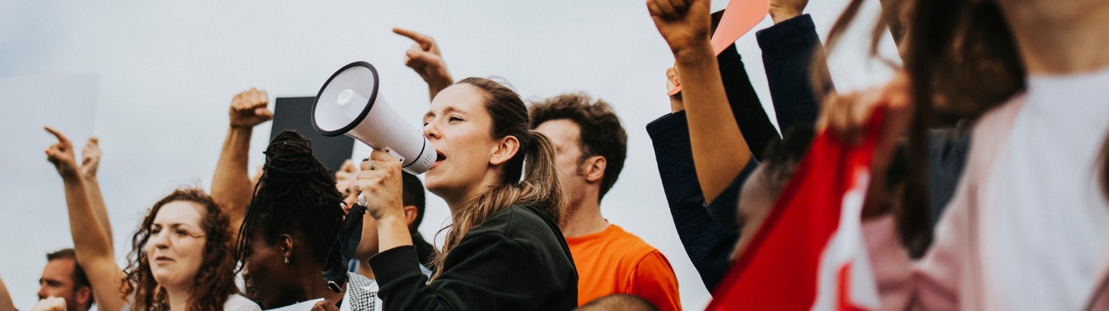 A group of protestors with signs and a megaphone.