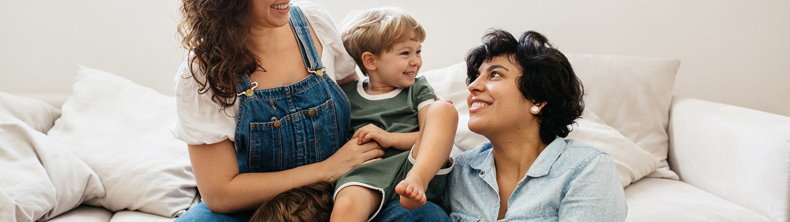Queer couple playing with their children at home.