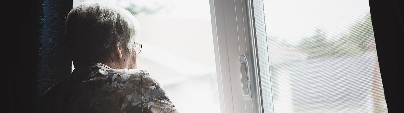 Senior woman looks out window