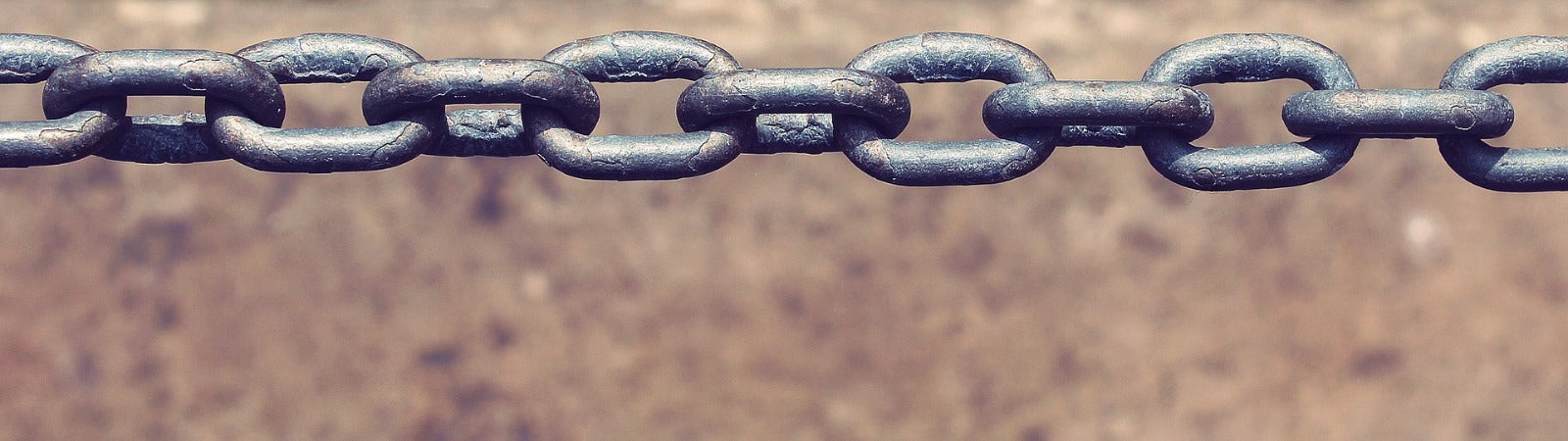 a metal chain with a neutral textured tan background.