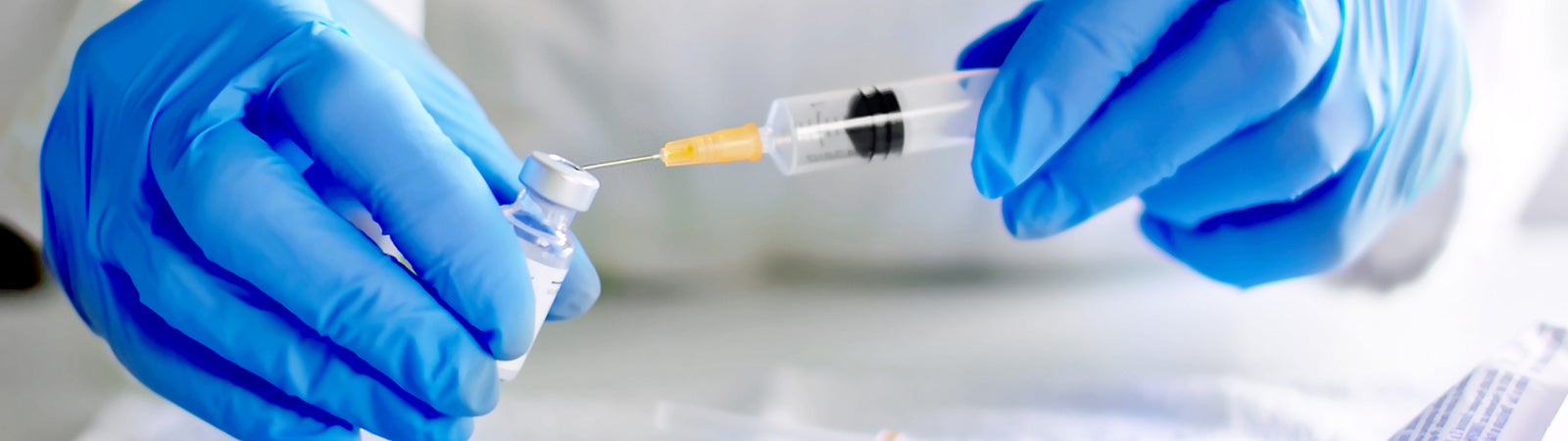 Hands filling a syringe