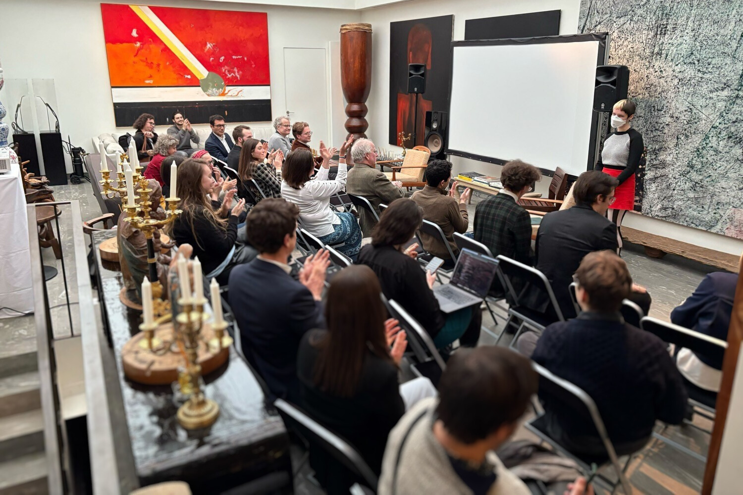 B addresses clapping crowd at Public AI House.