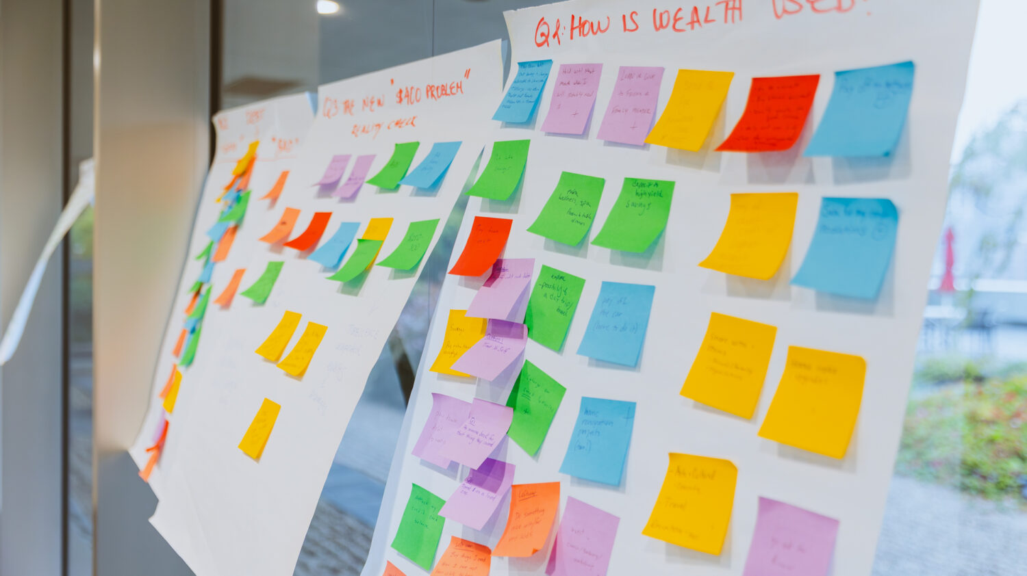 Post-it notes cover a wall during a brainstorm activity