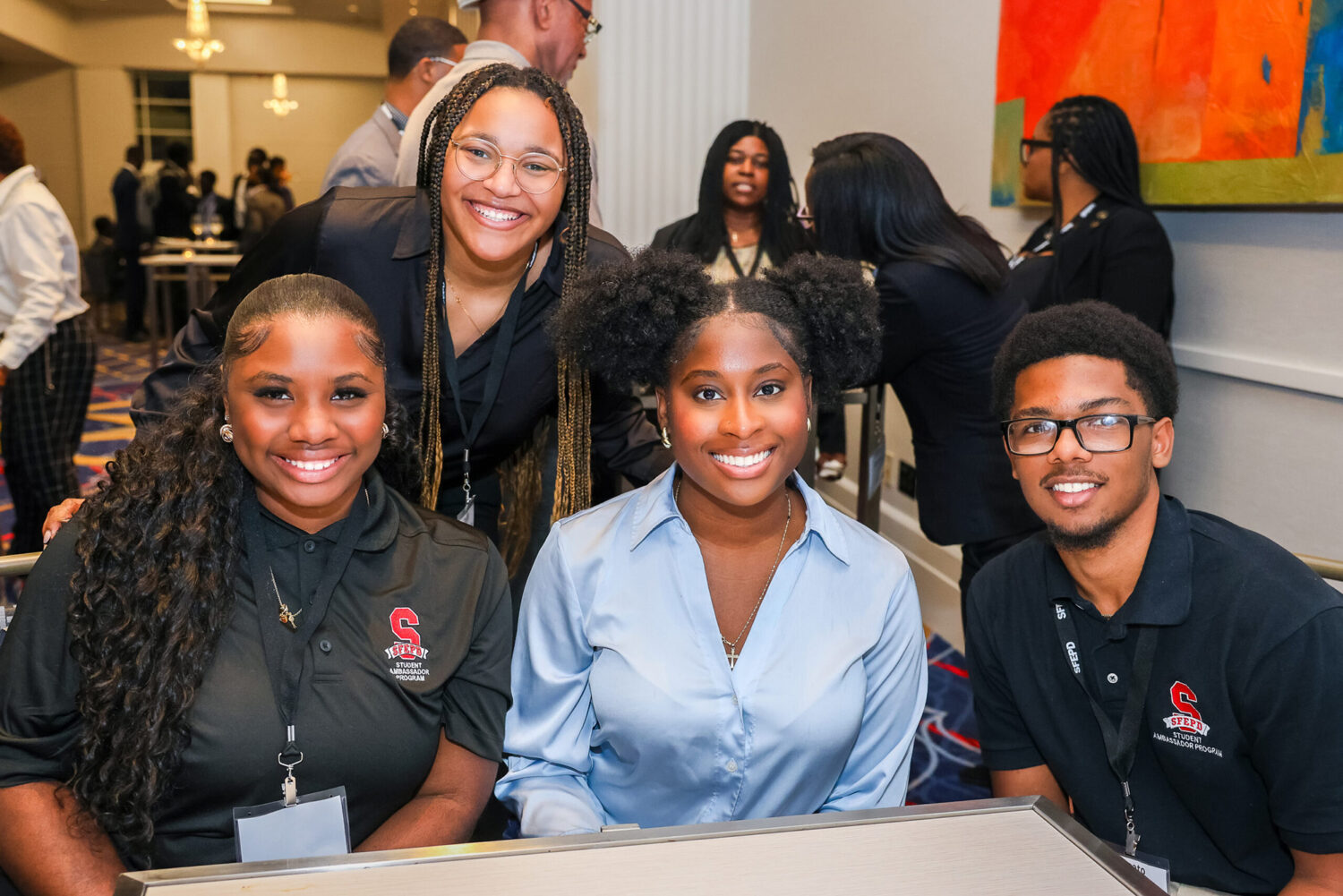 Four students pose for a photo at a conference.