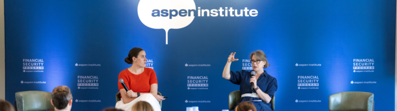 Two women sit on stage