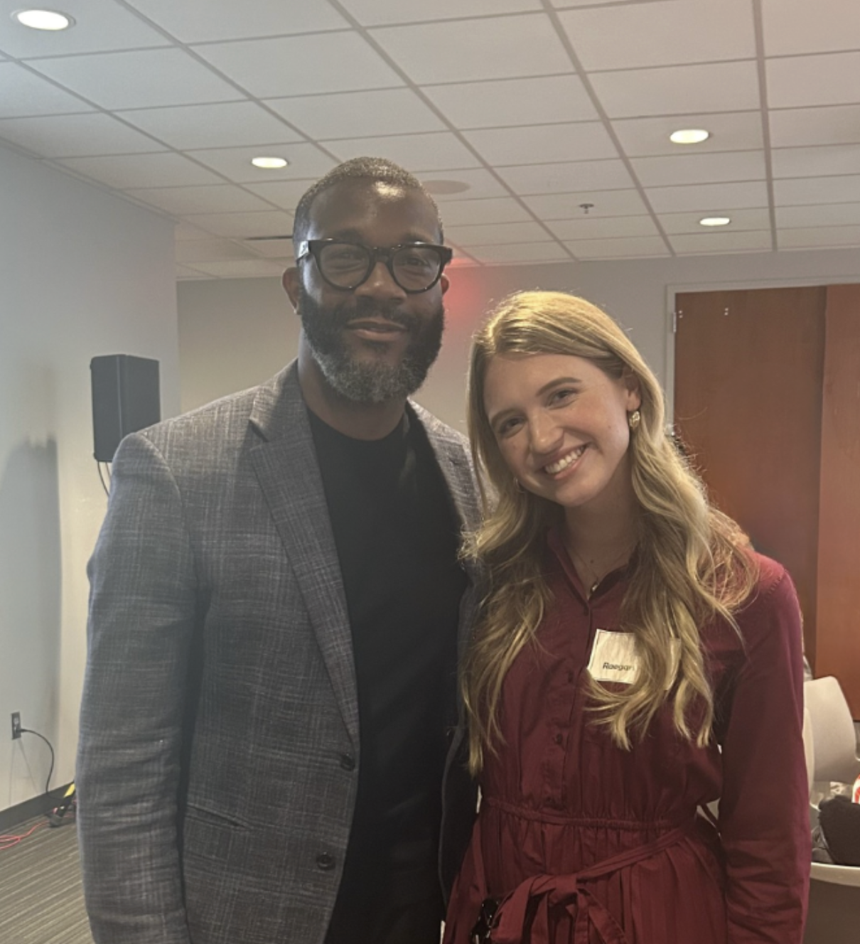 Mayor Woodfin (left) and Raegan Harris (right) pose together indoors.