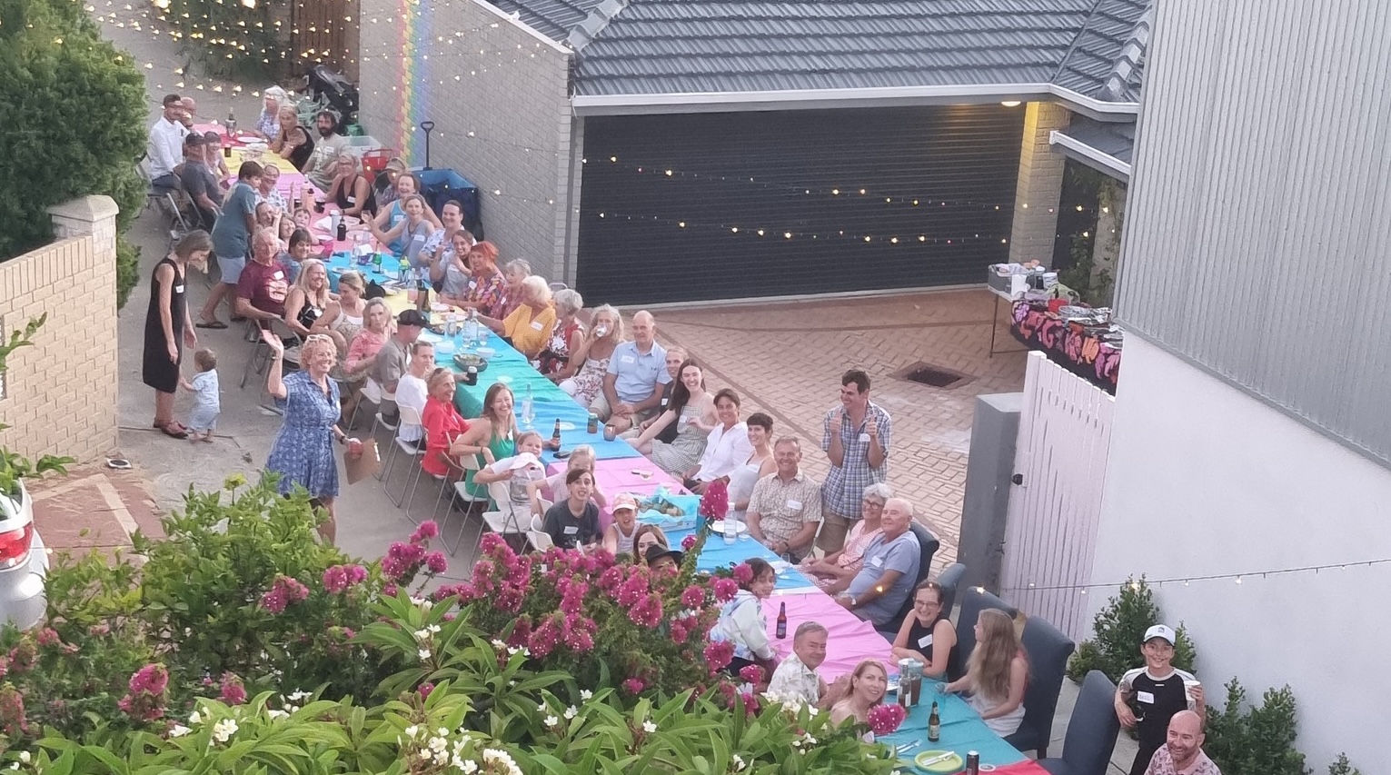 Neighbors enjoying a community meal and shaking hands. Photo credit: Andy Clayton-King